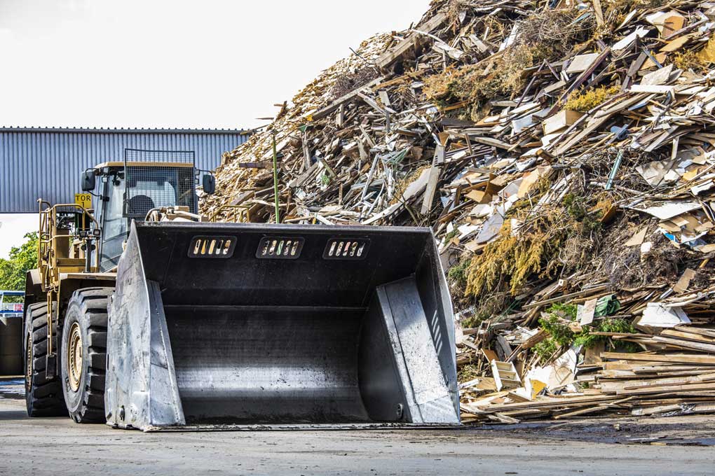 Radlader vor dem Gebrauchtholzhaufen